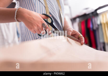 Young female hands cutting paper with scissors Stock Photo
