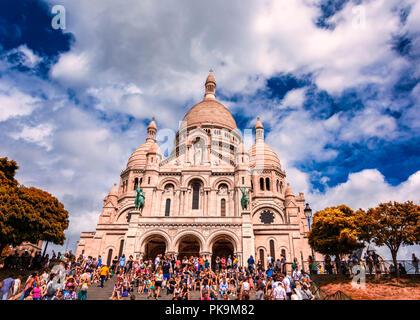sacre-coeur limestone Cathedral montmarte , paris,france during sunnyday with green conopy and tourists sitting on steps Stock Photo
