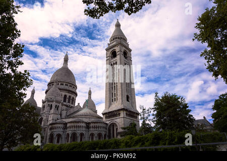 sacre-coeur limestone Cathedral montmarte , paris,france during sunnyday with green conopy forming natural frame Stock Photo