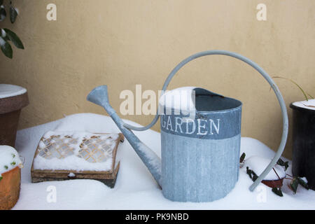 Watering can in snow Stock Photo