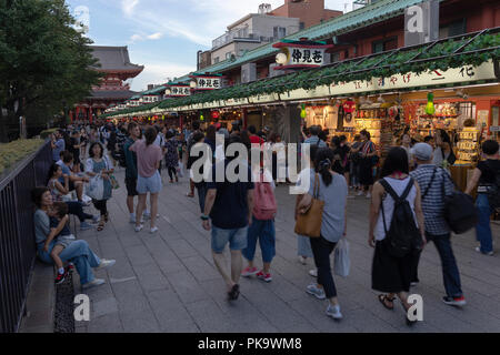 Visitors to Senso-ji Temple in Tokyo pass by the Nakamise-dori shopping arcade that leads up to the temple Stock Photo