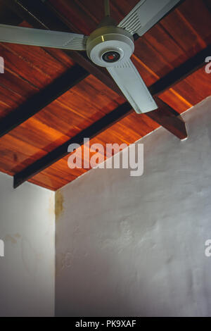 Ceiling fan on the background of a brown wooden ceiling Stock Photo