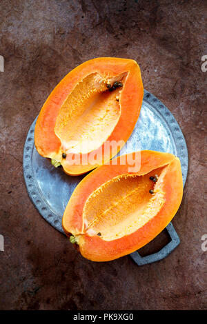 Ripe papaya without seeds cut into two halves Stock Photo