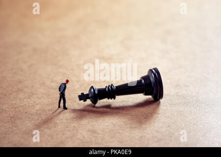 Pensive businessman looking at chess figure. Stock Photo