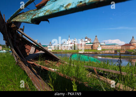 View of the Solovetsky Monastery through a large hole in an old wooden boat on a summer day Stock Photo
