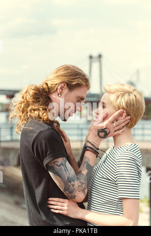 boyfriend with tattoos and stylish girlfriend cuddling near river Stock  Photo - Alamy