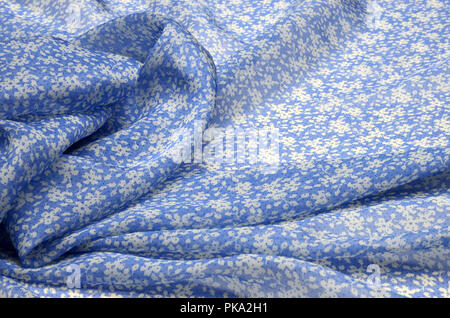 Chiffon white floral ornament on light blue silk Stock Photo