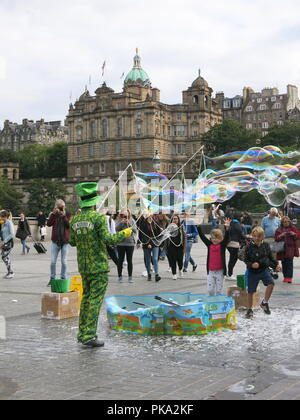 The Edinburgh Festival may be over, but the fun continues with street entertainment for the crowds on Princes Street from Bubble Man's giant bubbles. Stock Photo