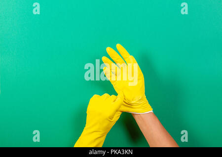Hands putting on yellow rubber gloves Stock Photo