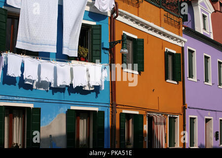 Gaily coloured houses on the Fondamenta Pontinello Sinistra, Burano, Venice, Italy, with the weekly wash hanging out to dry Stock Photo