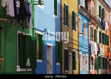 Burano, Venice, Italy: brightly coloured houses on Calle Broetta, with laundry hanging out to dry Stock Photo