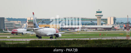 GATWICK AIRPORT, ENGLAND, UK – AUGUST 30 2018: Norwegian Airlines planes prepare to take off from Gatwick Airport. Stock Photo
