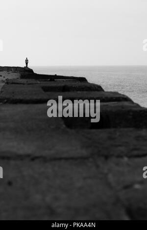 Adult man walking on the beach wall silhouette Stock Photo