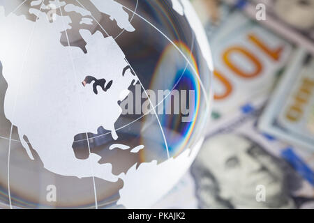 Glass World Globe On Top of Hundred Dollar Bills. Stock Photo