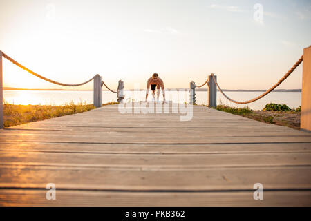 Concentrared young sportsman is ready to run outdoors in the morning. Stock Photo