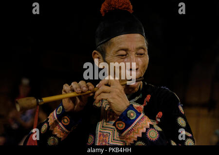 An elderly member of Hmong Tribe playing the traditional Klui bamboo ...