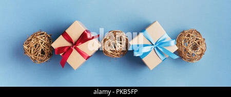 Banner with two Christmas gift boxes and balls on blue background. Gift boxes tied with red and blue ribbons. Stock Photo