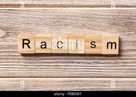Racism word written on wood block. Racism text on table, concept. Stock Photo