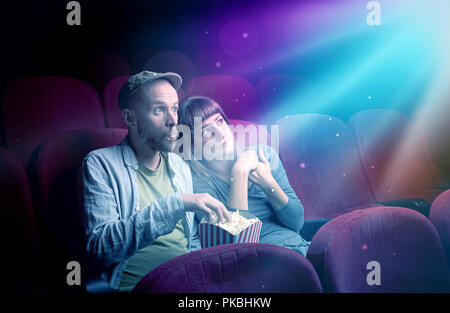 Teenager couple cuddling and watching the climax part of the movie Stock Photo