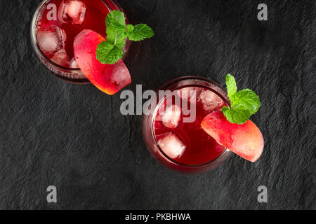 Overhead photo of vibrant red drinks with mint on black Stock Photo