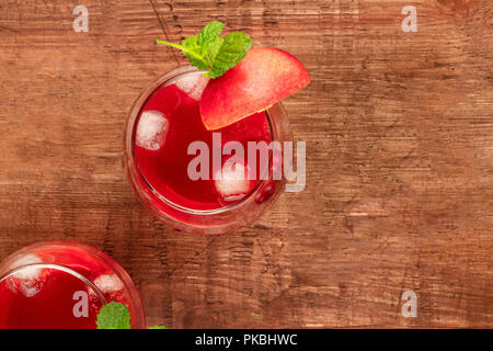 Overhead photo of vibrant red drinks with berries on a rustic background Stock Photo