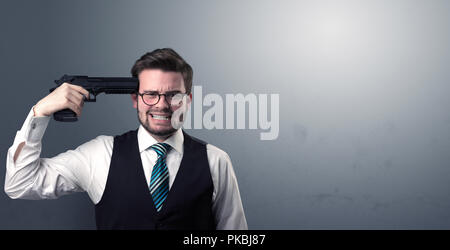 Young lost businessman man shooting his head with gun Stock Photo