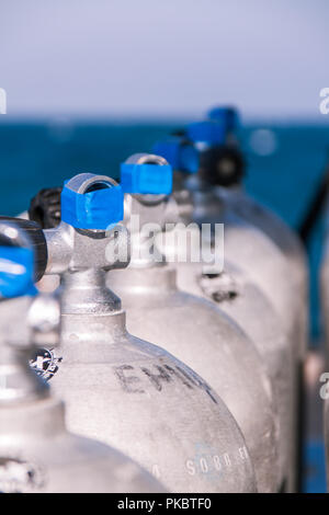 Scuba Diving Tanks with Blue Tape and Sea in the Background Stock Photo