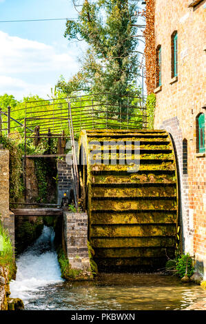 An old disused water wheel covered in moss in The Cotswolds, England, UK Stock Photo