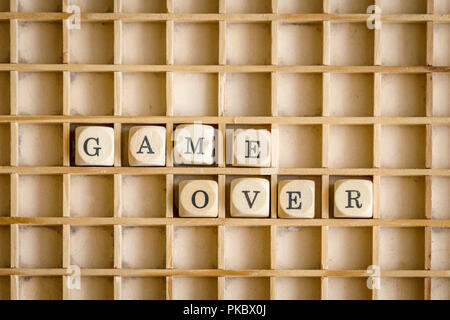 Game over sign made of wooden dices on a shelf in retro style Stock Photo
