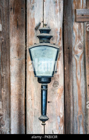 Vintage lamp with dusty glass hanging on a wooden wall Stock Photo