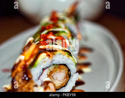 Delicious sushi roll, plated nicely with extravagant sauces. Stock Photo