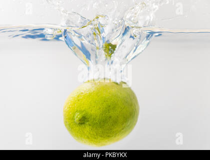 Fresh lime falling into the water. Suitable for advertisement. Stock Photo