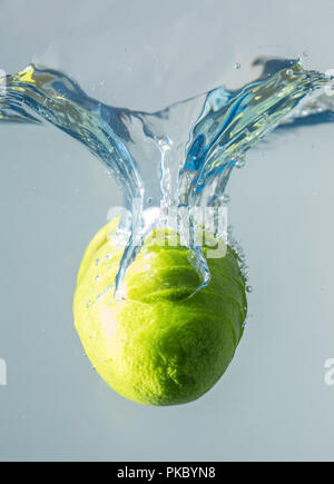 Fresh lime falling into the water. Suitable for advertisement. Stock Photo