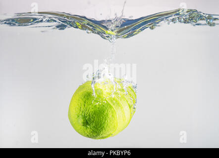 Fresh lime falling into the water. Suitable for advertisement. Stock Photo