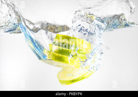 Fresh lime falling into the water. Suitable for advertisement. Stock Photo