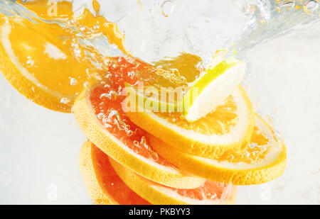 Grapefruit, lime and orange falling to the water. Suitable for advertisement. Stock Photo
