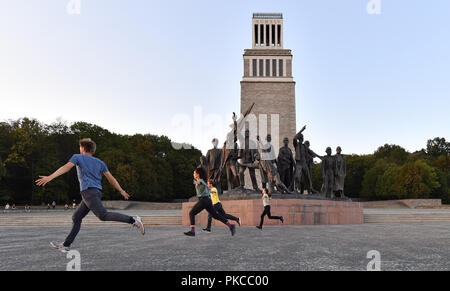 12 September 2018, Thuringia, Weimar: Young people walk past the bell tower and the sculpture of the Buchenwald prisoners of Fritz Cremer (1906-1993). 60 years after the inauguration of the Buchenwald memorial not far from the former Nazi concentration camp near Weimar, the securing work on the plant has been completed. According to the Buchenwald and Mittelbau-Dora Memorials Foundation, around 2.7 million euros have been invested in the preservation of the building substance from federal and state funds since 2010. According to the foundation, the memorial is the largest in memory of Nazi cri Stock Photo