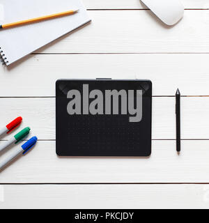 Modern Desktop of the artist. Black graphic tablet on white wooden table Stock Photo
