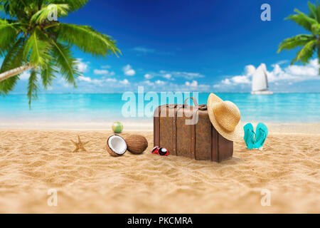 Travel holiday vacation suitcase with sunglasses, starfish, straw hat and beach slippers on the beautiful beach with palm trees. Advertisement on trav Stock Photo
