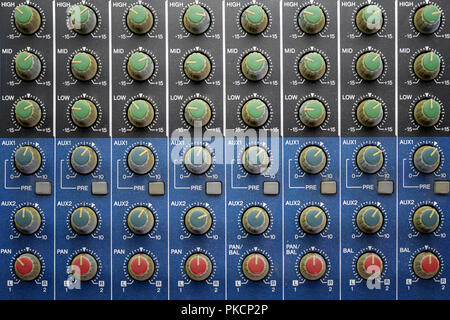 equalization and pan knobs on blue audio mixing table Stock Photo