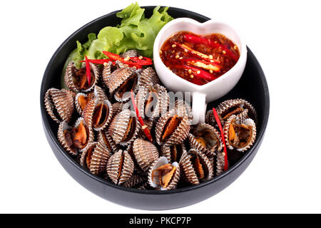 Isolated of Fresh and delicious soft-boiled blood cockles shell  served with spicy sauce  in Korea pattern black dish Stock Photo