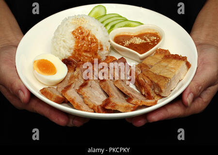 Thai food ready served,Jasmine rice with Chinese sausage,red herb pork steak,crispy streaky pork and boiled egg topped red sweet sauce served with cuc Stock Photo