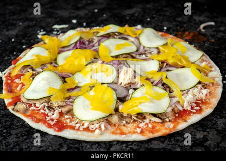 Vegetarian pizza on black table, ready to be baked Stock Photo
