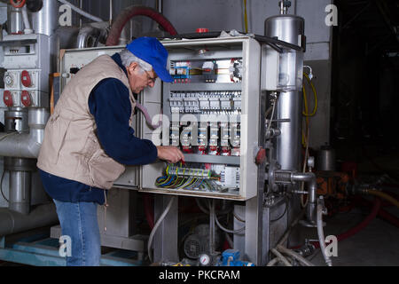 electrician at work with an electric panel Stock Photo