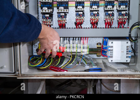 electrician at work with an electric panel Stock Photo