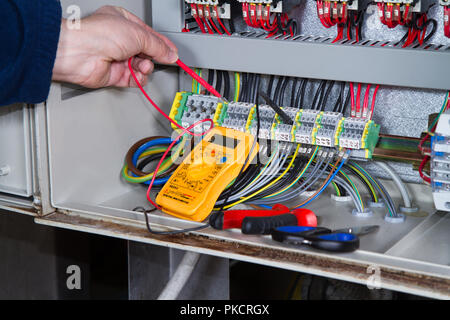 electrician at work with an electric panel Stock Photo