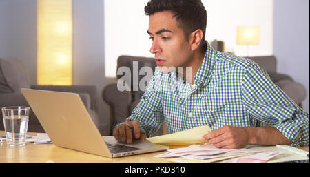 Hispanic man paying bills at home Stock Photo