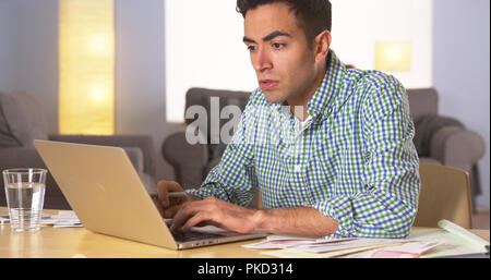 Mexican man paying bills at home Stock Photo