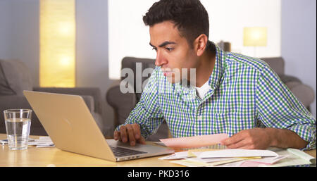 Hispanic man frustrated with his bills Stock Photo