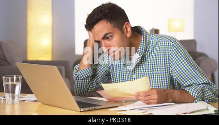 Mexican man feeling frustrated with bills Stock Photo